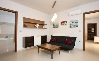 a living room with a couch and a table at Villa Cleopatra Private Heated Pool, Tennis & Football in Koskinou