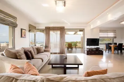 a living room with a couch and a table at Villa Cleopatra Private Heated Pool, Tennis & Football in Koskinou