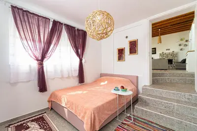 a bedroom with a bed and a window and stairs at CHRYSANTHI'S STONE HOUSE in Afantou