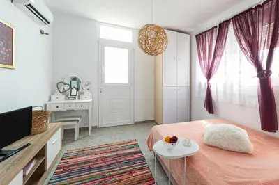 a bedroom with a bed and a table and a window at CHRYSANTHI'S STONE HOUSE in Afantou
