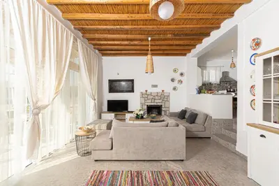 a living room with a couch and a fireplace at CHRYSANTHI'S STONE HOUSE in Afantou