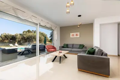 a living room with a couch and a table at Mika Villa in Afantou