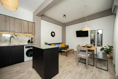a kitchen and living room with a couch and a table at Potnia House in the center of Rhodes in Rhodes Town
