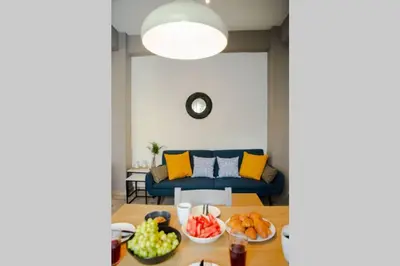 a living room with a blue couch and a table with fruits at Potnia House in the center of Rhodes in Rhodes Town