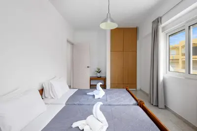 two white swans sitting on two beds in a bedroom at ISKAS EVILION in Rhodes Town