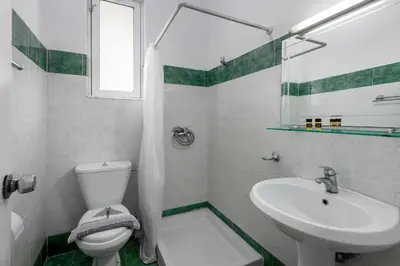 a white bathroom with a sink and a toilet at ISKAS EVILION in Rhodes Town
