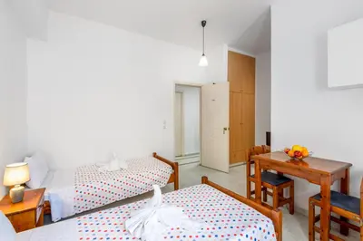 a bedroom with two beds and a table and a desk at ISKAS EVILION in Rhodes Town