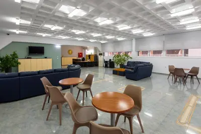 a waiting room with tables and chairs and a couch at ISKAS EVILION in Rhodes Town