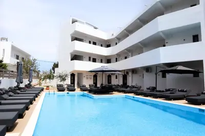 a hotel with a swimming pool and lounge chairs at Penélope Hotel in Ialyssos