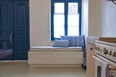 a window seat in a kitchen with a blue door at 1890 Fanourakis House in Halki