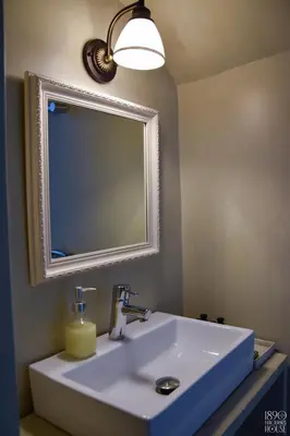 a bathroom with a white sink and a mirror at 1890 Fanourakis House in Halki