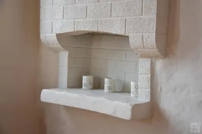 four coffee cups sitting on a shelf in a brick wall at 1890 Fanourakis House in Halki