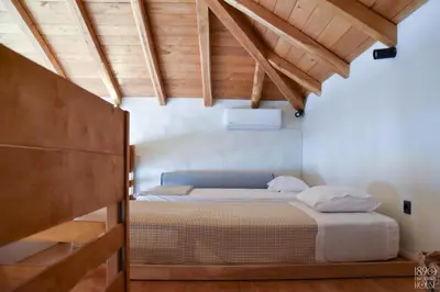 a bedroom with a bed in a room with wooden ceilings at 1890 Fanourakis House in Halki