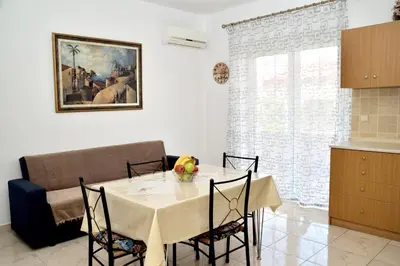 a dining room with a table and chairs and a window at ANTONIOS apartments in Archangelos