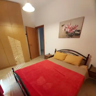 a bedroom with a bed with a red blanket at ANTONIOS apartments in Archangelos