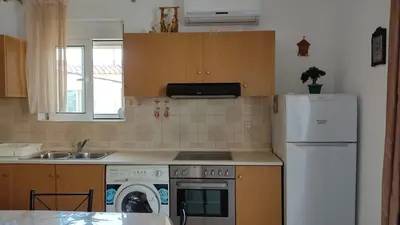 a kitchen with a white refrigerator and a dishwasher at ANTONIOS apartments in Archangelos