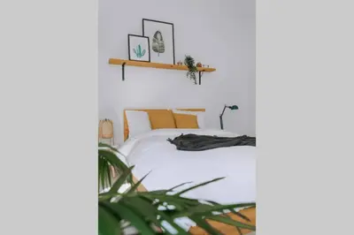 a bedroom with a bed with white sheets and a plant at Never Ending Summer Villa in Asgourou