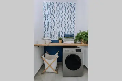a laundry room with a washing machine under a counter at Never Ending Summer Villa in Asgourou