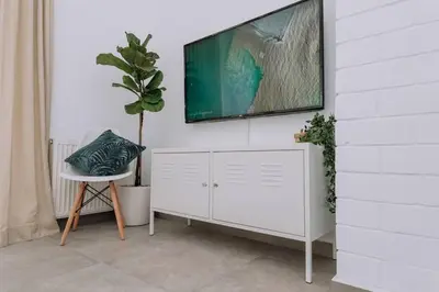 a living room with a tv on a wall at Never Ending Summer Villa in Asgourou