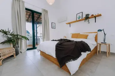 a bedroom with a bed with a black blanket on it at Never Ending Summer Villa in Asgourou