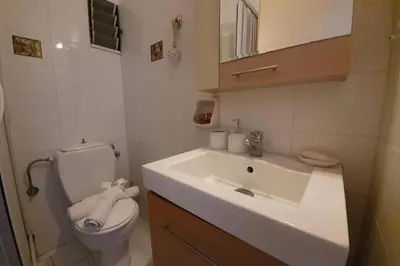 a bathroom with a white sink and a toilet at Amarantou Apartment - Rhodes City Center in Rhodes Town