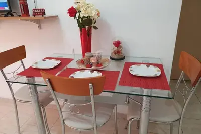 a glass table with chairs and a vase with flowers at Amarantou Apartment - Rhodes City Center in Rhodes Town