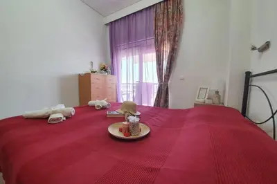 a bedroom with a red bed with stuffed animals on it at Amarantou Apartment - Rhodes City Center in Rhodes Town