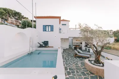 a villa with a swimming pool and a house at Kalathos Square luxury suites in Kalathos