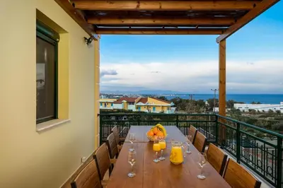 a table on a balcony with a view of the ocean at Siena Pool Villa in Koskinou
