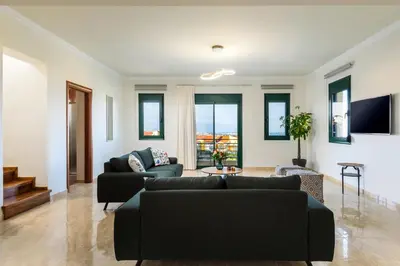 a living room with two couches and a tv at Siena Pool Villa in Koskinou