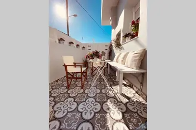 a balcony with a table and chairs on a floor at Casa del Sud in Apolakkiá