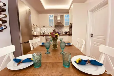 a kitchen with a wooden table with plates and glasses at Casa del Sud in Apolakkiá