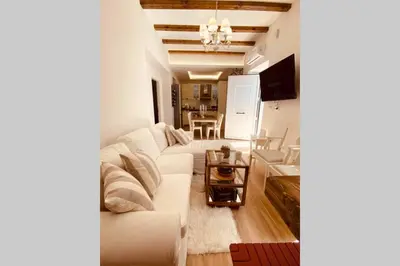 a living room with a white couch and a table at Casa del Sud in Apolakkiá