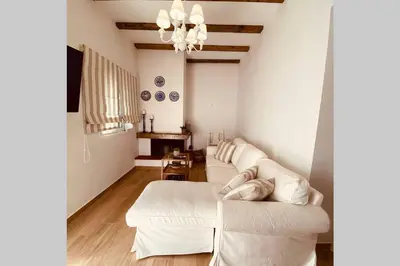 a living room with a white couch and a chandelier at Casa del Sud in Apolakkiá