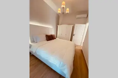 a bedroom with a white bed and a chandelier at Casa del Sud in Apolakkiá
