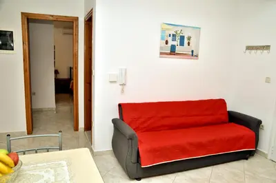 a red couch sitting in a living room at ANTONIOS apartments in Archangelos