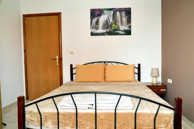 a bedroom with a bed and a waterfall at ANTONIOS apartments in Archangelos