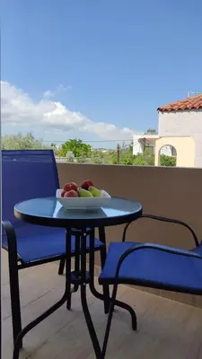 a table with a bowl of fruit on a balcony at ANTONIOS apartments in Archangelos