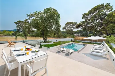 a patio with a table and chairs next to a swimming pool at Aurum Villas in Ialyssos