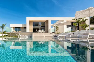 a swimming pool in front of a house at Aurum Villas in Ialyssos