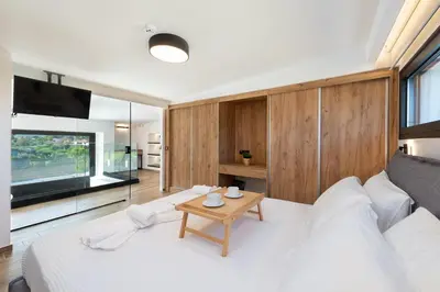 a living room with a white bed and a table at Aurum Villas in Ialyssos