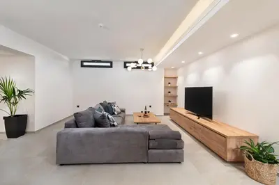 a living room with a couch and a flat screen tv at Aurum Villas in Ialyssos