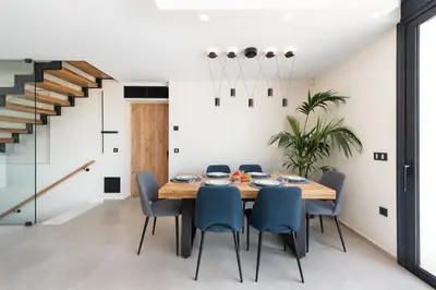 a dining room with a wooden table and blue chairs at Aurum Villas in Ialyssos