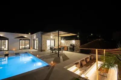 a villa with a swimming pool at night at Terra Secreta Luxury Villas in Lardos