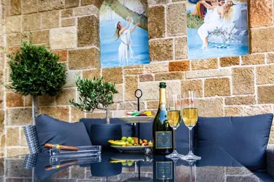 a table with two glasses of wine and a bowl of fruit at Chateau Anax Luxury suites in Rhodes Town