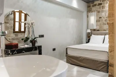 a bathroom with a bed and a tub and a sink at Chateau Anax Luxury suites in Rhodes Town