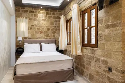 a bedroom with a bed in a brick wall at Chateau Anax Luxury suites in Rhodes Town
