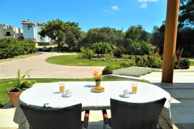 a white table with chairs and drinks on a patio at Fiore di Rodi - Private Pool, Jacuzzi and Barbecue in Ialyssos