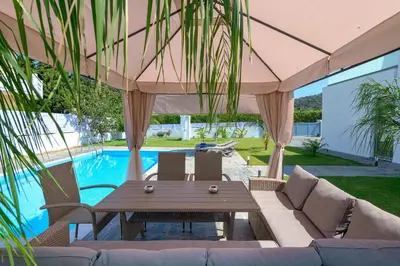 a patio with a table and chairs and a pool at Villa Costa in Ixia