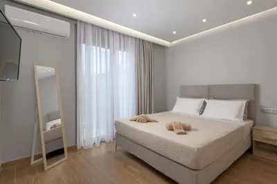a bedroom with a bed with a mirror and a television at Villa Costa in Ixia